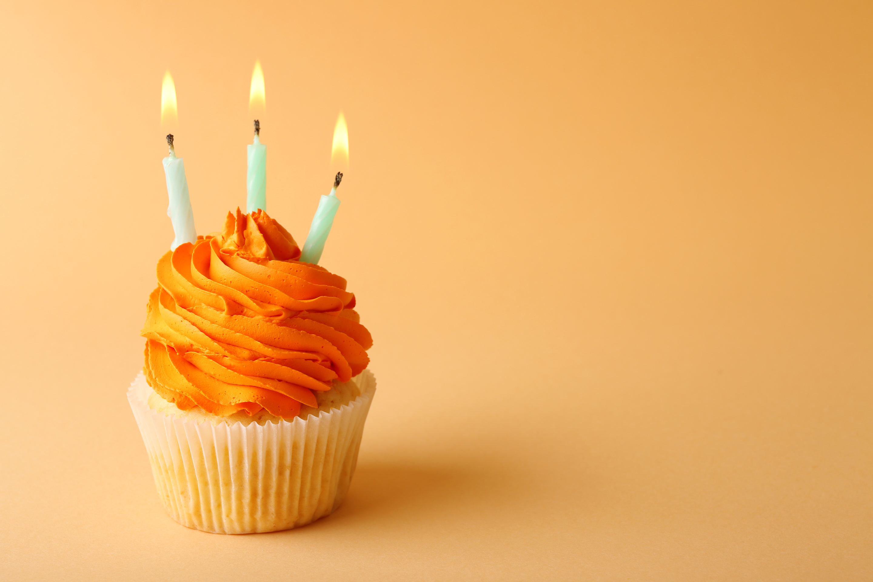 Birthday Cupcake with Candle on Orange  Background